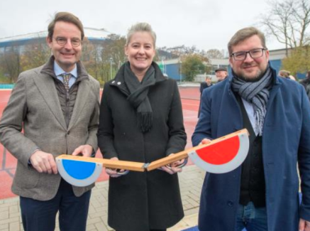 Drei Personen vor einer Tartanbahn