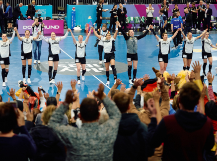 Handballerinnen verbeugen sich vor dem Publikum auf der Tribüne