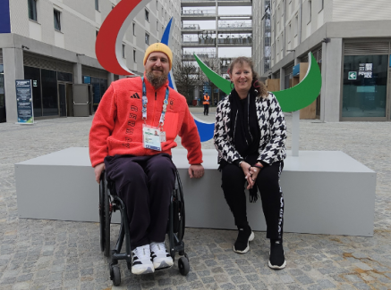 Andrea Milz und ein Para Athlet im Rollstuhl vor einer Agitos Skulptur in Mailand
