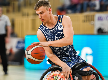 Max Lammering im Rollstuhl dribbelt einen Basketball