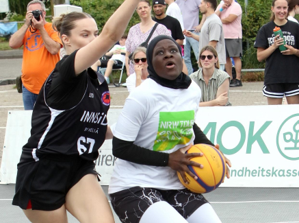 Zwei 3x3-Spielerinnen auf einem Außengelände kämpfen um einen Ball