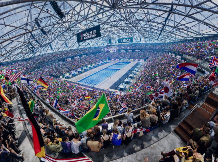 KI-Bild der Veltins Arena bei Olympischen Spielen mit einem Schwimmbecken in der Mitte und Fans drumherum