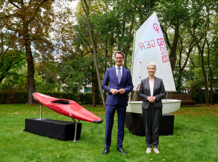 Ministerpräsidenten Schwesig und Wüst mit einem Kanu und einem Segelboot im Hintergrund