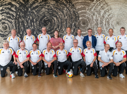 Andrea Milz inmitten zweier Reihen mit Ü70/U75-Fußballspielern