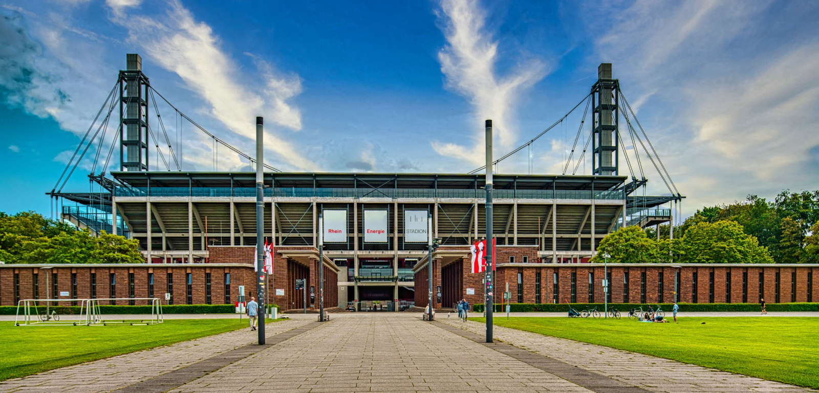 Rheinenergiestadion von außen mit Wiese im Vordergrund