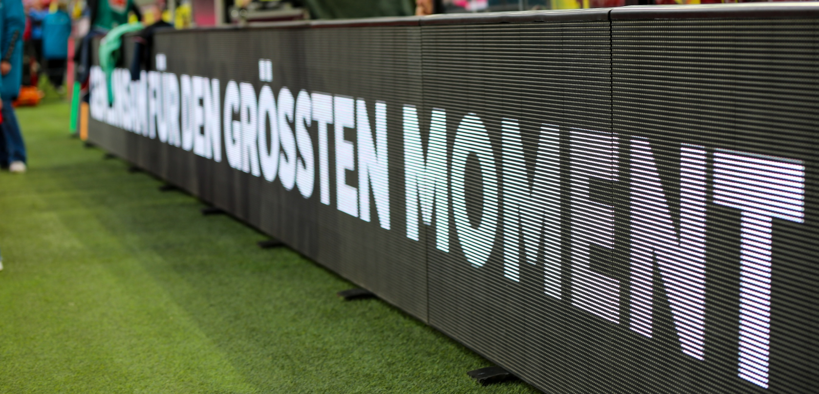 Dunkle Bande im Fußballstadion mit der Aufschrift "Für den größten Moment"