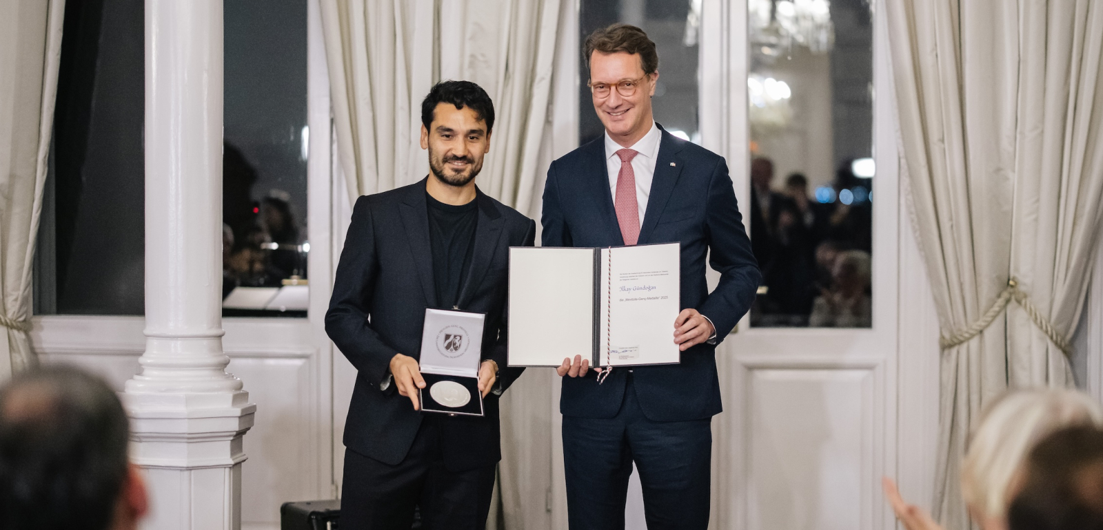 Ministerpräsident Wüst und Ilkay Gündogan mit Medaille und Auszeichnung