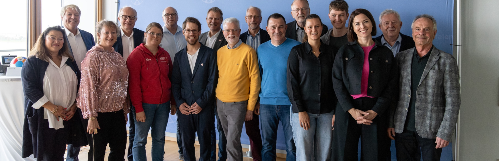 Mehrere Menschen vor einem Banner des Landes NRW