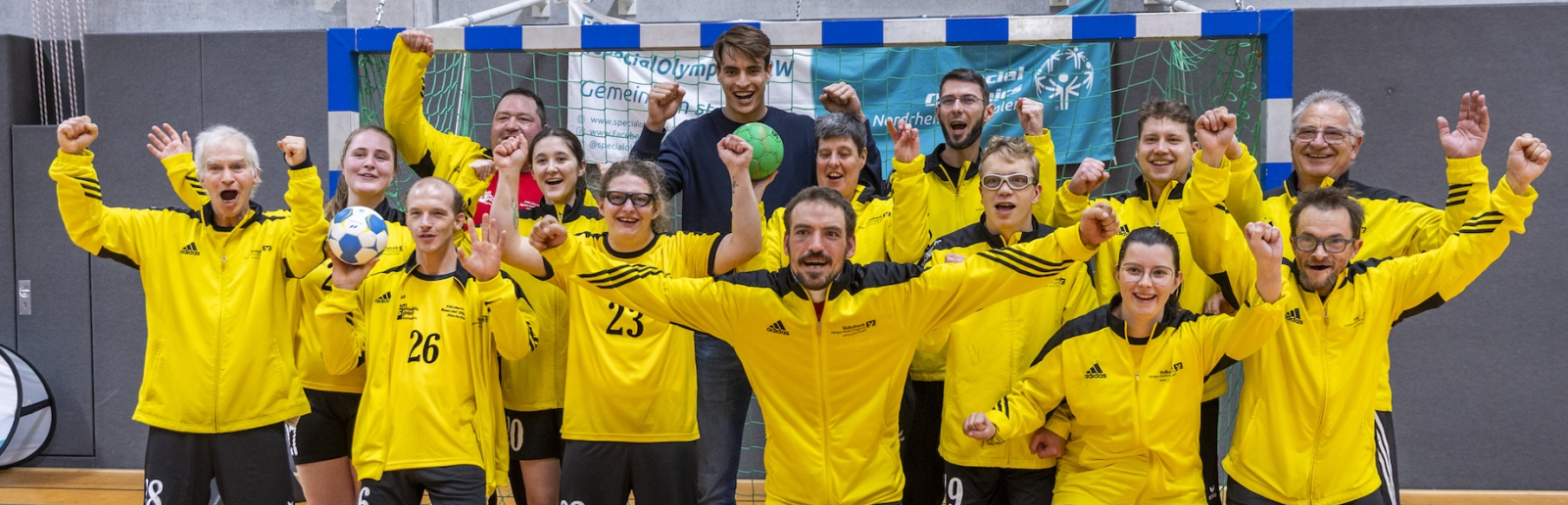 Julian Köster jubelt mit vielen Personen bei einem Handball-Training