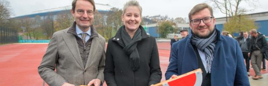 Drei Personen vor einer Tartanbahn