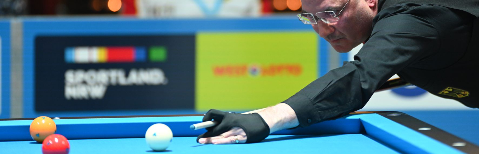 Mann mit Queue spielt Billard