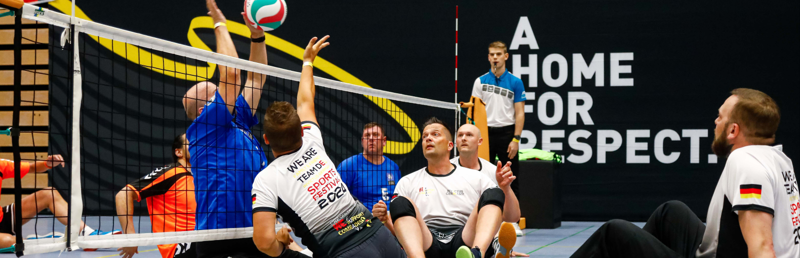 Mehrere Teilnehmende spielen Sitz-Volleyball