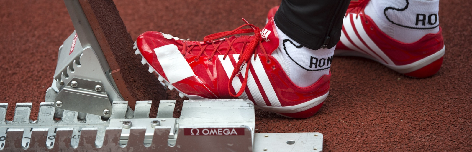 Sportler mit roten Schuhen präpariert den Startblock