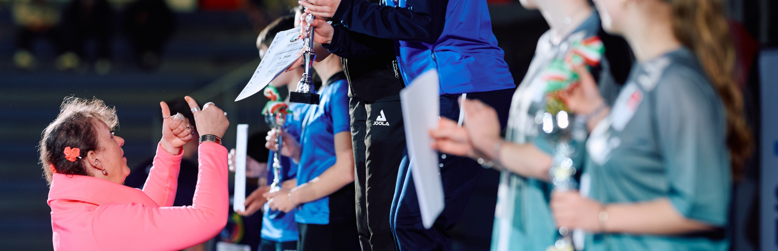 Andrea Milz in rosafarbenem Oberteil übergibt Preise beim Landesfinale