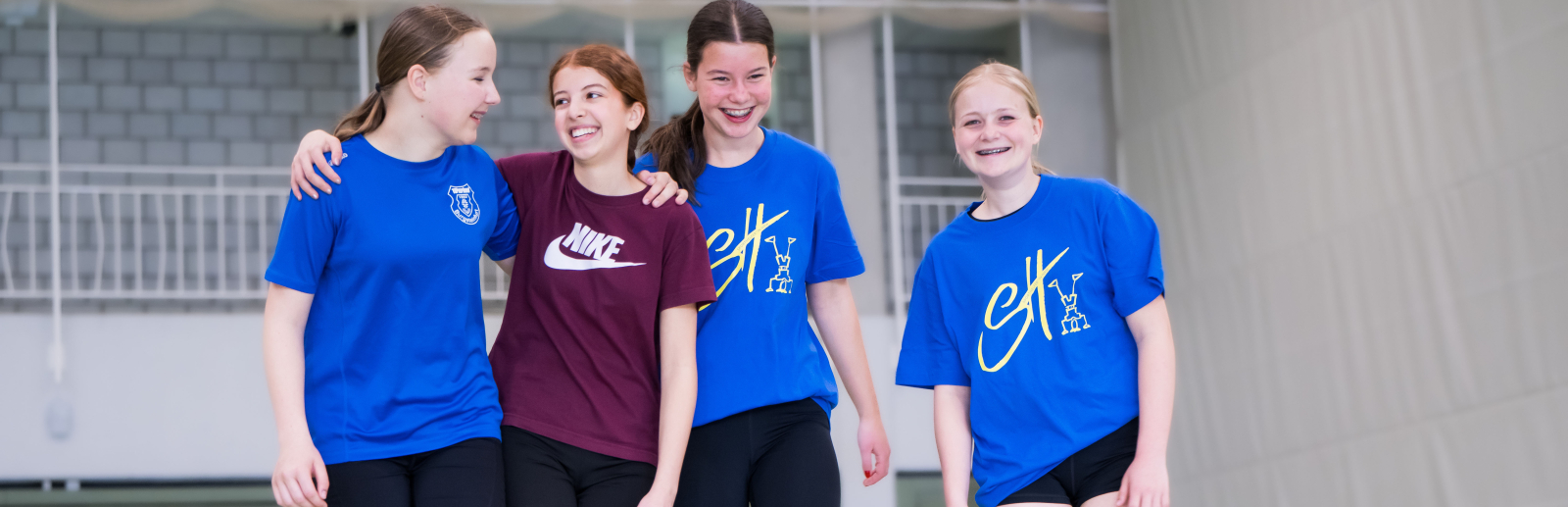 Vier junge Frauen in Sportkleidung in einer Halle