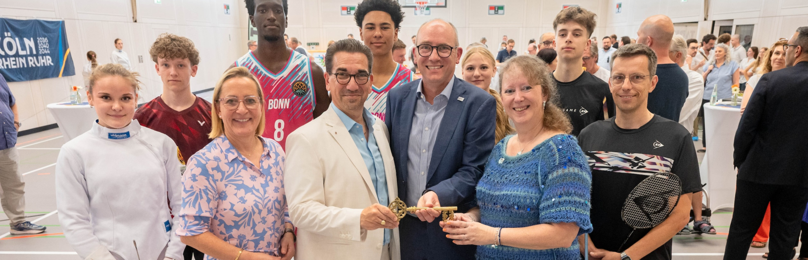 Viele Personen in einem Innenraum mit Andrea Milz in blauer Kleidung