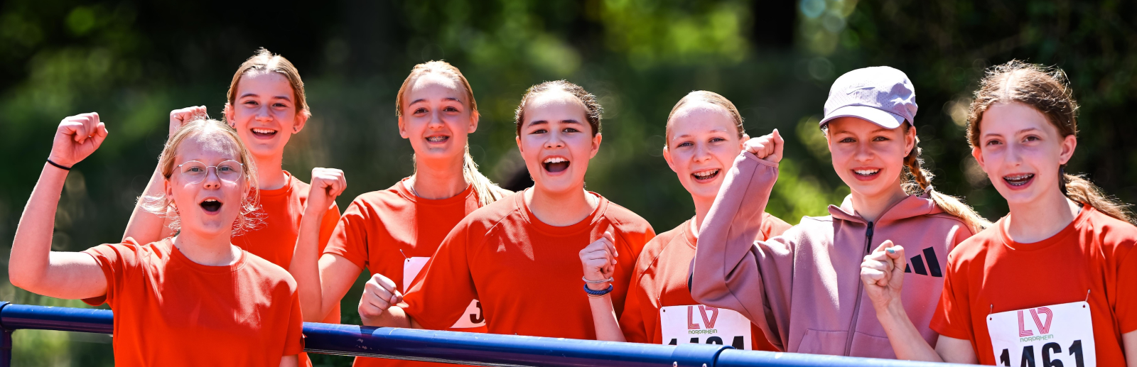 Junge Frauen in roter Sportkleidung jubeln