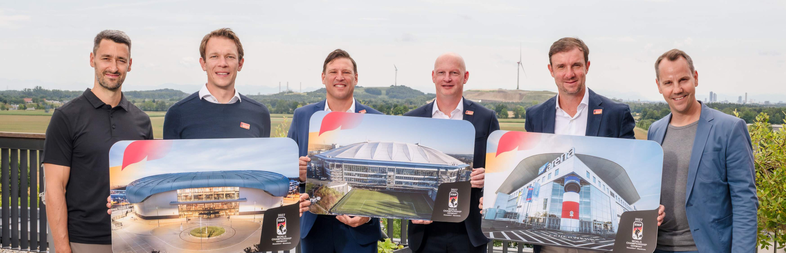 Sechs Personen halten Schilder zur Eishockey-WM 2027