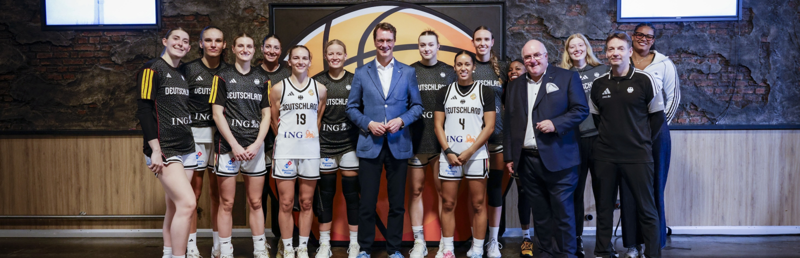 Ministerpräsident Wüst umgeben von Basketballerinnen