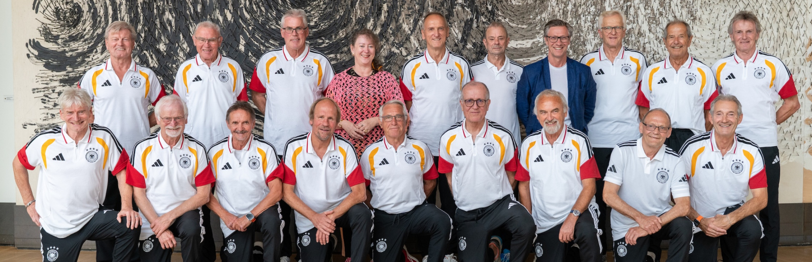 Andrea Milz inmitten zweier Reihen mit Ü70/U75-Fußballspielern