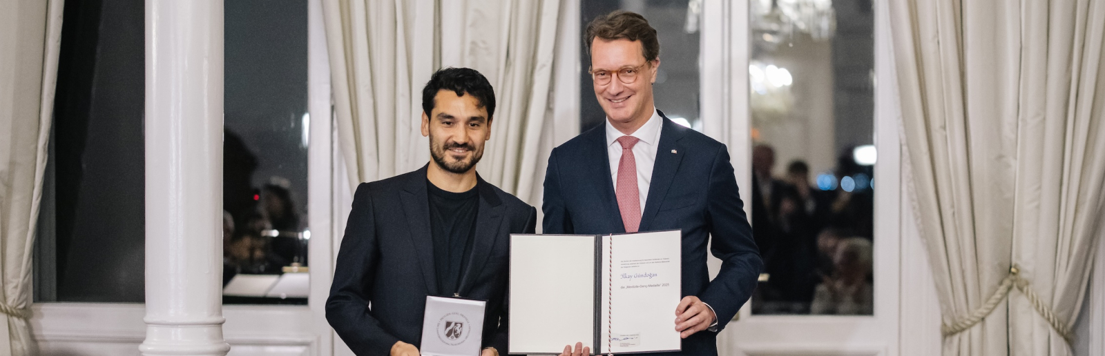 Ministerpräsident Wüst und Ilkay Gündogan mit Medaille und Auszeichnung