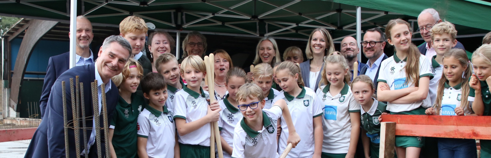 Gruppe von Kindern sowie einige Erwachsene bei der Grundsteinlegung