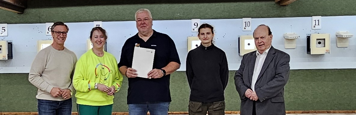 Andrea Milz in einer Sportschützen-Halle mit vier weiteren Personen