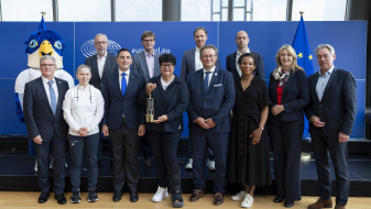 Vertreter der Staatskanzlei NRW im EU-Parlament mit Maskottchen der Rhine-Ruhr 2025