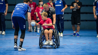 Kind im Rollstuhl mit Handball 