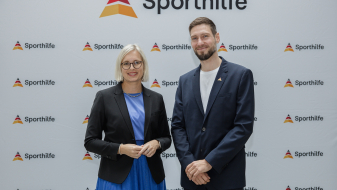 Dr. Christiane Schenderlin und Max Hartung vor einem Sporthilfe-Screen