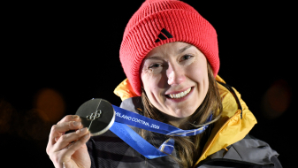 Laura Nolte hält Silbermedaille, vor dunklem Hintergrund