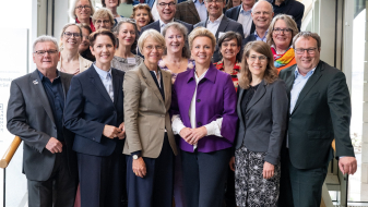 Gruppe von mehreren Personen vor einer Fensterfront
