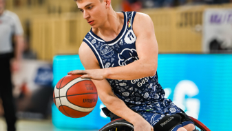 Max Lammering im Rollstuhl dribbelt einen Basketball