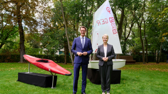 Ministerpräsidenten Schwesig und Wüst mit einem Kanu und einem Segelboot im Hintergrund