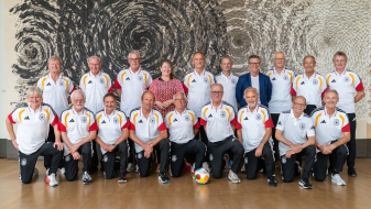 Andrea Milz inmitten zweier Reihen mit Ü70/U75-Fußballspielern